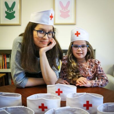 Dziewczynka i mama w opaskach lekarskich.